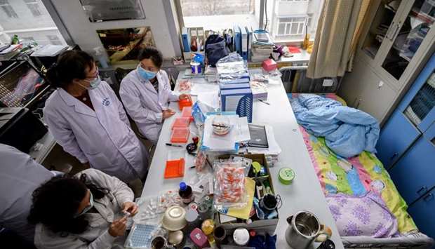 Workers are seen next to a bed placed inside an office at a centre for disease control and prevention, as the country is hit by an outbreak of the novel coronavirus, in Taiyuan, Shanxi province, China