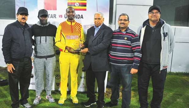 QCA Operations Manager Manzoor Ahmad (third from right) presents the Player of the Match award to Ugandau2019s Deusdedit Muhumuza (third from left) at the Asian Town Stadium on Friday.
