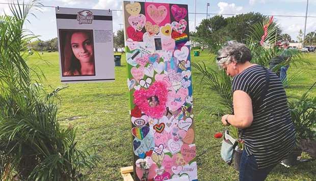 A woman leaves a tribute in front of the memorial of one of the 17 victims of Marjory Stoneman Douglas High School shooting in Parkland, Florida during the second anniversary of the massacre on Friday.