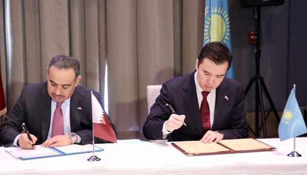 HE al-Kuwari and Dalenov co-sign the minutes of the meeting at the conclusion of fifth session of the Qatari- Kazakh Joint Higher Committee.