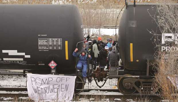 Supporters of the indigenous Wetu2019suwetu2019en Nation occupy railway tracks as part of a protest against British Columbiau2019s Coastal GasLink pipeline, in Toronto.