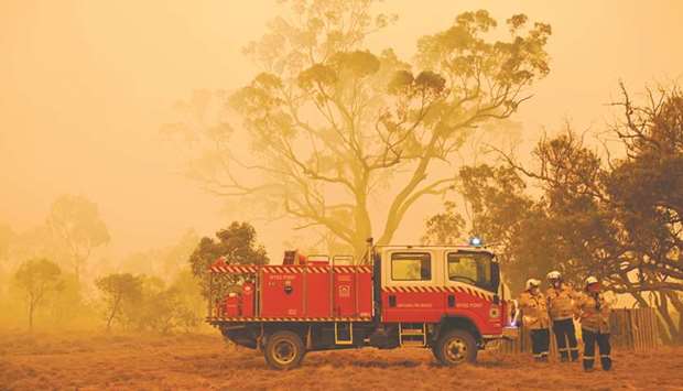 Firefighters protecting a property from bushfires burning near the town of Bumbalong south of Canberra.