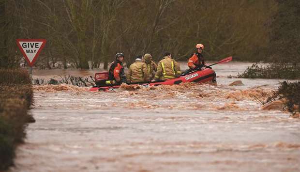Members of the Fire and Rescue Service evacuate residents trapped by flood waters after the River Teme burst its banks in Lindridge, western England, yesterday after Storm Dennis caused flooding across large swathes of Britain.