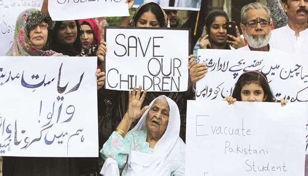 Family members hold signs during protest in Karachi to demand the evacuation of Pakistani students from Chinau2019s Wuhan city.