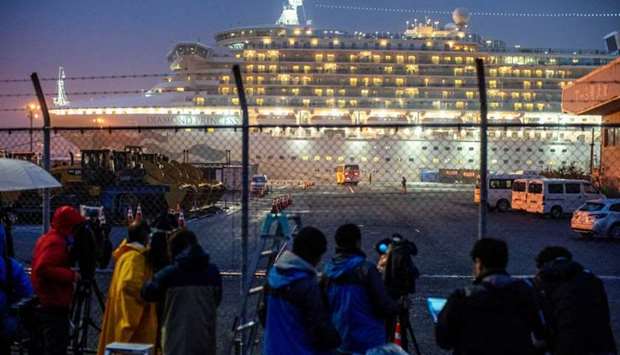 A bus arrives near the cruise ship Diamond Princess, where dozens of passengers were tested positive for coronavirus, at Daikoku Pier Cruise Terminal in Yokohama, south of Tokyo