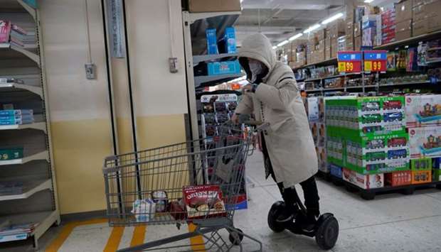 A man rides on an electric unicycle while shopping at a Walmart, as the country is hit by an outbreak of the novel coronavirus, in Beijing's central business district, China