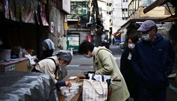 A woman buys food in Tokyo's Tsukiji area. AFP
