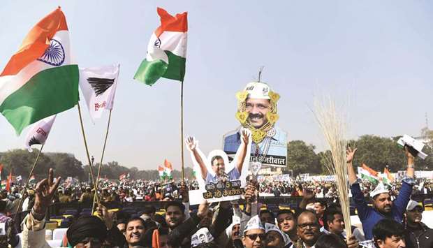 Supporters of the Aam Aadmi Party (AAP) hold cut outs of party president Arvind Kejriwal at the swearing-in ceremony in New Delhi yesterday.