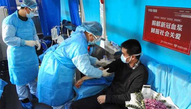 A man (R) who has recovered from the COVID-19 coronavirus infection donating plasma in Lianyungang in China's eastern Jiangsu province
