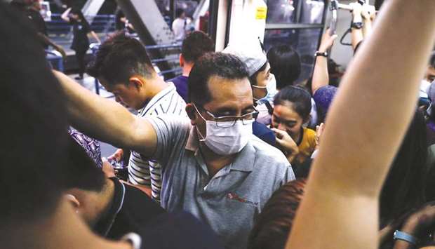 Passengers wear protective masks inside a crowded train in Manila, yesterday.