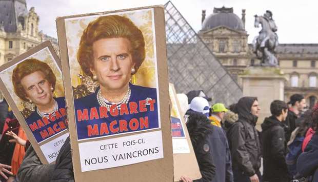 Protesters hold placards reading u2018Margaret Macron, this time we will winu2019 under a photomontage of late British prime minister Margaret Thatcher and Macron as they demonstrate in front of Parisu2019s Louvre Museum yesterday as part of a multi-sector strike against the French governmentu2019s pensions overhaul.