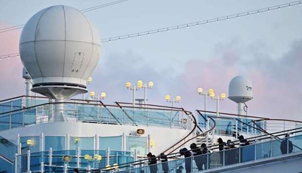 People still in quarantine due to fears of the new COVID-19 coronavirus stand on the deck of the Diamond Princess cruise ship docked at the Daikoku Pier Cruise Terminal in Yokohama