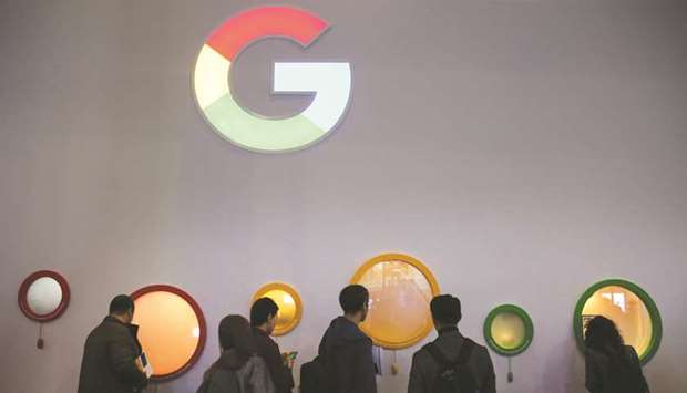 Attendees peer through portholes on the Google stand on the opening day of the MWC Barcelona in Barcelona on February 25, 2019.