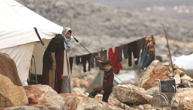 Syrians who fled pro-regime forces attacks in the Idlib and Aleppo provinces are pictured at a makeshift camp for displaced people yesterday, north of the city of Idlib, near the Turkish border.