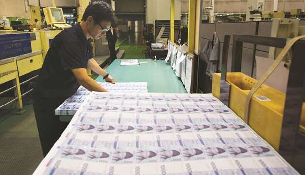 An employee inspects sheets of South Korean 1,000 won banknote at the Korea Minting, Security Printing & ID Card Operating Corp factory in Geyongsan (file).