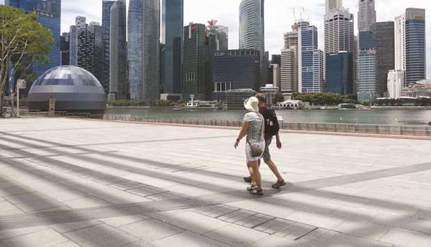 Visitors walk along a walkway at Marina Bay in Singapore.