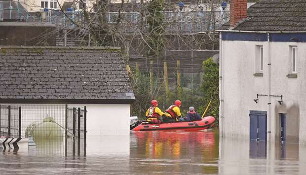 South Wales Fire and Rescue personnel take a resident through floodwaters in Monmouth, south Wales, yesterday.
