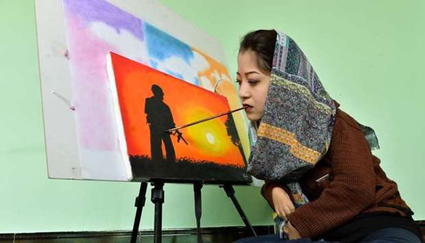 19-year-old Afghan artist Robaba Mohammadi painting in her studio in Kabul