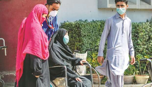 A paramedic staff member helps a victim on a wheelchair at a hospital, a day following an apparent toxic gas leak, in Karachi yesterday.