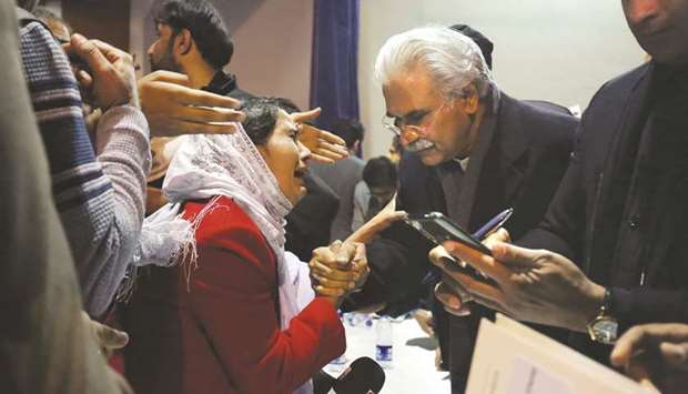 Health Minister, Zafar Mirza (right), interacts with the mother of a student, who is stuck in the locked down Hubei province at the centre of Chinau2019s coronavirus outbreak, as people demand evacuation of their children during a meeting in Islamabad, yesterday.