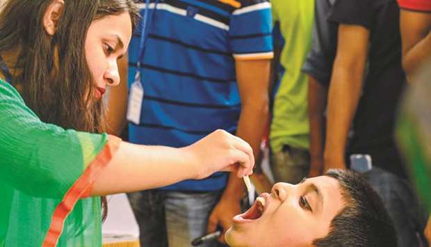 A child receives an oral cholera vaccine from a health worker during a vaccination campaign in Dhaka yesterday.