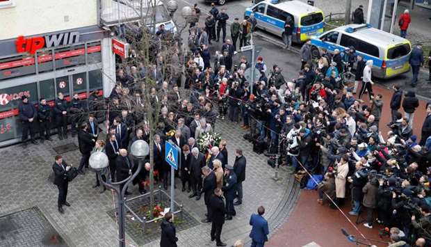 German Justice Minister Christine Lambrecht, German Interior Minister Horst Seehofer, Hesse's State Premier Volker Bouffier and Hesse state Interior Minister Peter Beuth lay flowers watched by people from their appartments near the 'Midnight' Bar, one of the bar targeted in a shooting at the Heumarkt in the centre of Hanau