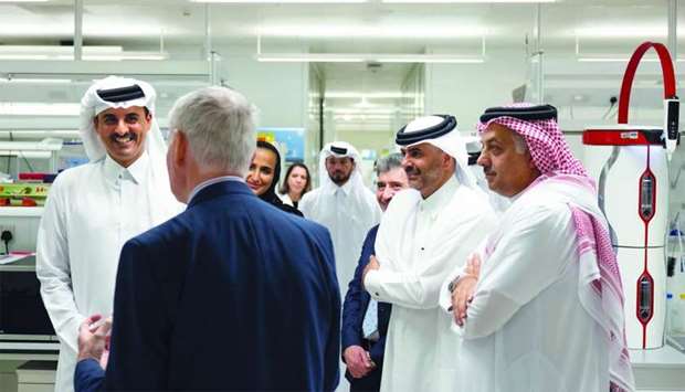 His Highness the Amir Sheikh Tamim bin Hamad al-Thani interacts with an official during his visit to Qatar Foundationu2019s Hamad Bin Khalifa University (HBKU) Research Complex