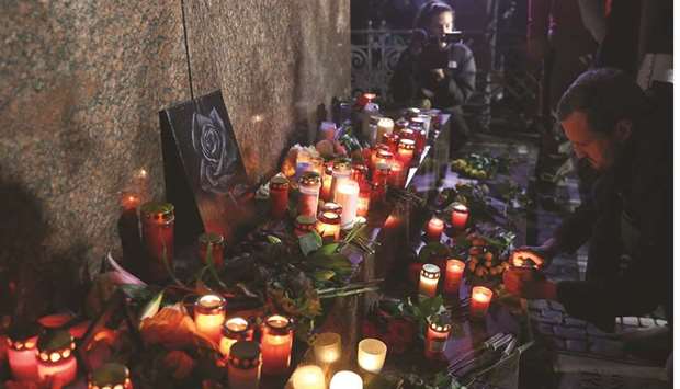 A man places a candle during a vigil in Frankfurt for the victims of the shooting in Hanau.