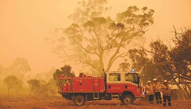 Firefighters protect a property from bushfires burning near the town of Bumbalong south of Canberra yesterday.