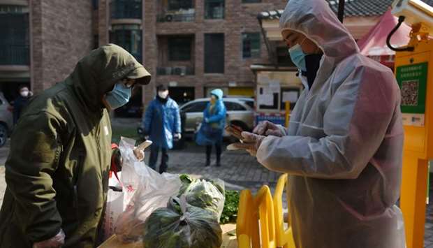 A resident collects vegetables purchased through group orders at the entrance of a residential compound in Wuhan, the epicentre of the novel coronavirus outbreak, Hubei province, China