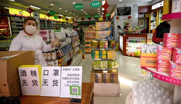Employees wearing protective face masks at a pharmacy in Beijing.