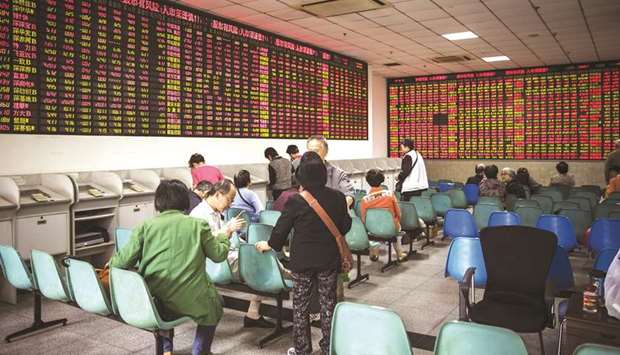 Investors sit in front of an electronic stock board at a securities brokerage in Shanghai. Chinau2019s stock traders are navigating the vagaries of the countryu2019s coronavirus data for clues on when euphoria fanned by Beijingu2019s emergency support measures may peak.