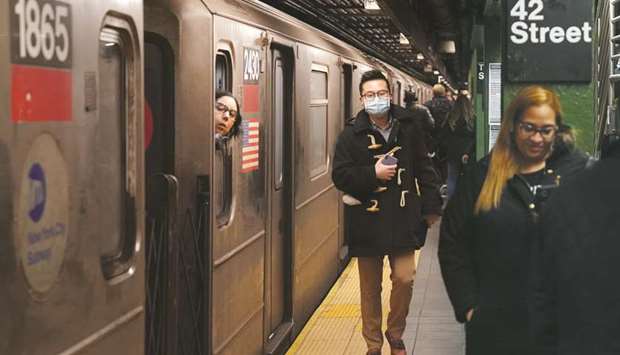 A passenger wears a surgical mask in the subway station at Times Square in New York.