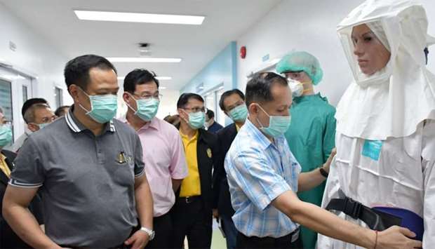 Thailand's Health Minister Anutin Charnvirakul (L) viewing display of protective clothings in Bamrasnaradura Infectious Disease Institute in Nonthaburi outside Bangkok where patients infected with SARS-like virus are confined.