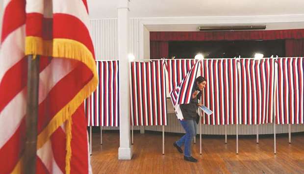 FILE PHOTO: A voter leaves a voting booth after casting her ballot in the stateu2019s presidential primary election in Greenfield, New Hampshire, US on February 11.