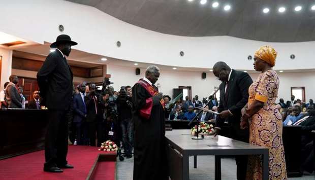 South Sudan's First Vice President Riek Machar takes the oath of office in front of President Salva Kiir and Chief Justice Chan Reech Madut, at the State House in Juba