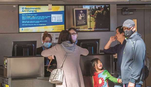 Standby passengers make inquiries at a check-in counter, after the departure of an Air China flight to Beijing, as flights continue to be cancelled due to fears of the coronavirus, at Los Angeles Airport.