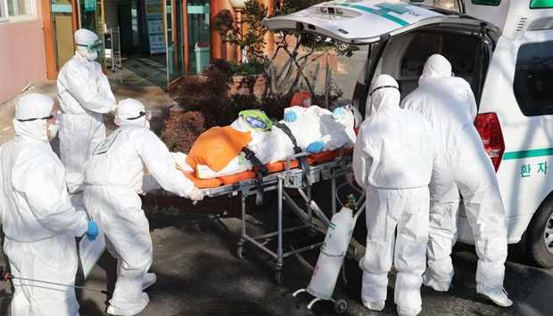 Medical workers wearing protective gear transfer a suspected coronavirus patient (C) to another hospital from Daenam Hospital 