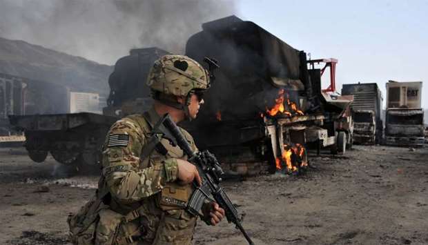 A US soldier investigates the scene of a suicide attack at the Afghan-Pakistan border crossing in Torkham, Nangarhar province