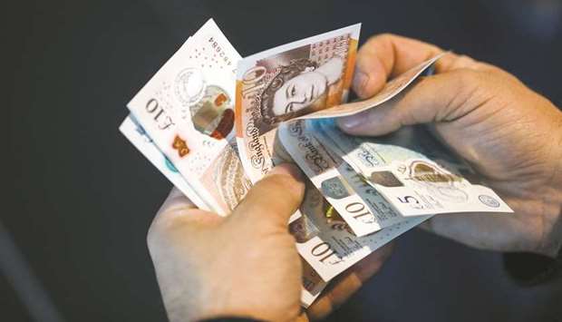 A man holds pound sterling banknotes in an arranged photograph in London. The US dollar is still king, and the euro its main challenger, but the pound is fast becoming a funding currency of choice for many emerging-market borrowers.