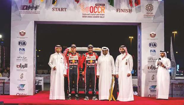 Ace Qatari driver Nasser Saleh al-Attiyah (second left) and his French co-driver Matthieu Baumel (centre) pose with Qatar Motor and Motorcycle Federation president Abdulrahman al-Mannai (second rigth and other officials during the ceremonial flag off for the Manateq Qatar Cross-Country Rally at Souq Waqif yesterday.