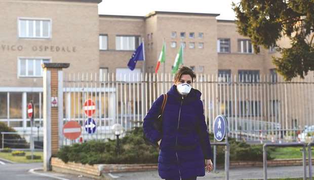 A nurse wearing a protective respiratory mask leaves the municipal hospital in Codogno, southeast of Milan, yesterday. The disease has now spread to more than two dozen countries and territories.