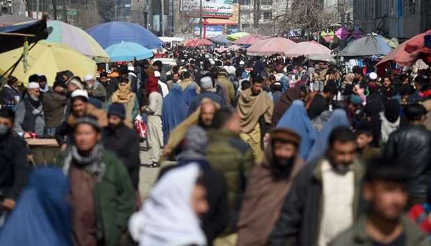 Pedestrians walk through a crowded market in Kabul