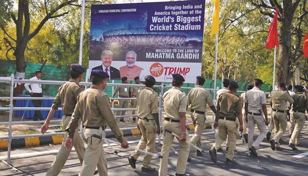 Police walk past a hoarding with the images of US President Donald Trump and Prime Minister Narendra Modi in Ahmedabad yesterday.