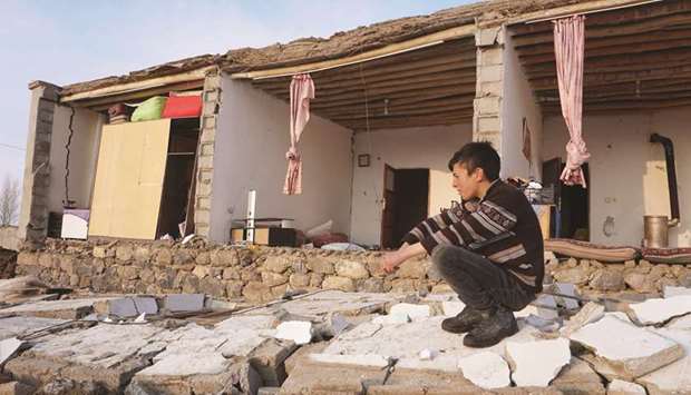 A child kneels by a destroyed house in Baskale, in the Van province.