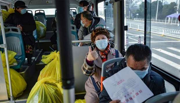 People who have recovered from the COVID-19 coronavirus infection leaving a hospital by bus in Wuhan in China's central Hubei province.