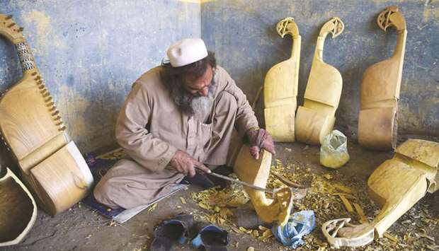 In this picture taken on December 10, 2019, a worker makes a traditional rabab musical instrument in a workplace on the outskirts of Peshawar.