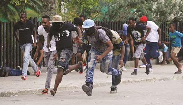Protesters run for cover during a shooting in Champ de Mars, Port-au-Prince, Haiti.