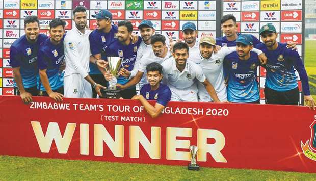 Bangladesh players pose with the trophy after winning the one-off Test match against Zimbabwe at the Sher-e-Bangla National Cricket Stadium in Dhaka yesterday. (AFP)