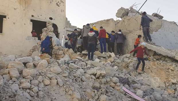Residents and rescuers search for victims in the rubble of a building following pro-regime force air strikes in the town of Binnish in Syriau2019s northwestern Idlib province, near the border with Turkey, yesterday.